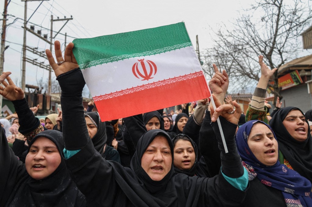 A Shiite Muslim woman holds an Iranian flag as she shouts anti-US and anti-Israel slogans during a protest against the killing of Iran's Supreme Leader Ayatollah Ali Khamenei on the outskirts of Srinagar, Jammu and Kashmir, on March 4, 2026.