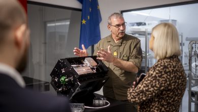Austria Defence Minister Klaudia Tanner takes a look at a critical component of her country's first military satellite.