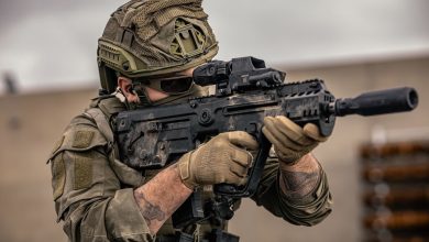 A personnel aiming an X95 rifle