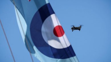 A compact quadcopter drone in flight alongside a Royal Air Force roundel banner during Exercise Agile Warrior, used to illustrate advances in quantum-resilient drone navigation and communications