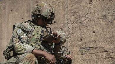 US soldier checks operational data on his end-user device during a field training exercise that demonstrates next-generation command and control radio technology.