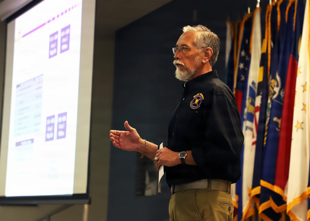 A speaker delivers a CJADC2 presentation during the Bold Quest 25 military interoperability demonstration.