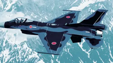 Japan Air Self-Defense Force F-2 fighter aircraft flying over snow-covered mountains.