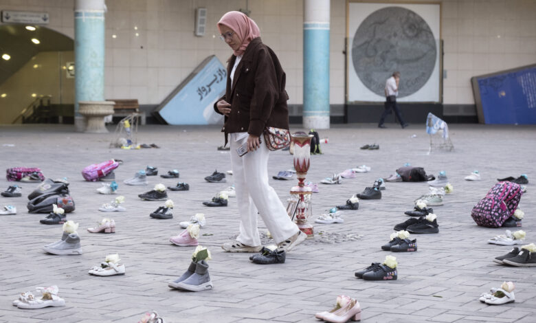 A woman walks through an installation symbolizing the Shajareh Tayyebeh School in Minab, which was destroyed in an airstrike, in a business district of Tehran, Iran, on April 22, 2026, as a ceasefire is extended.