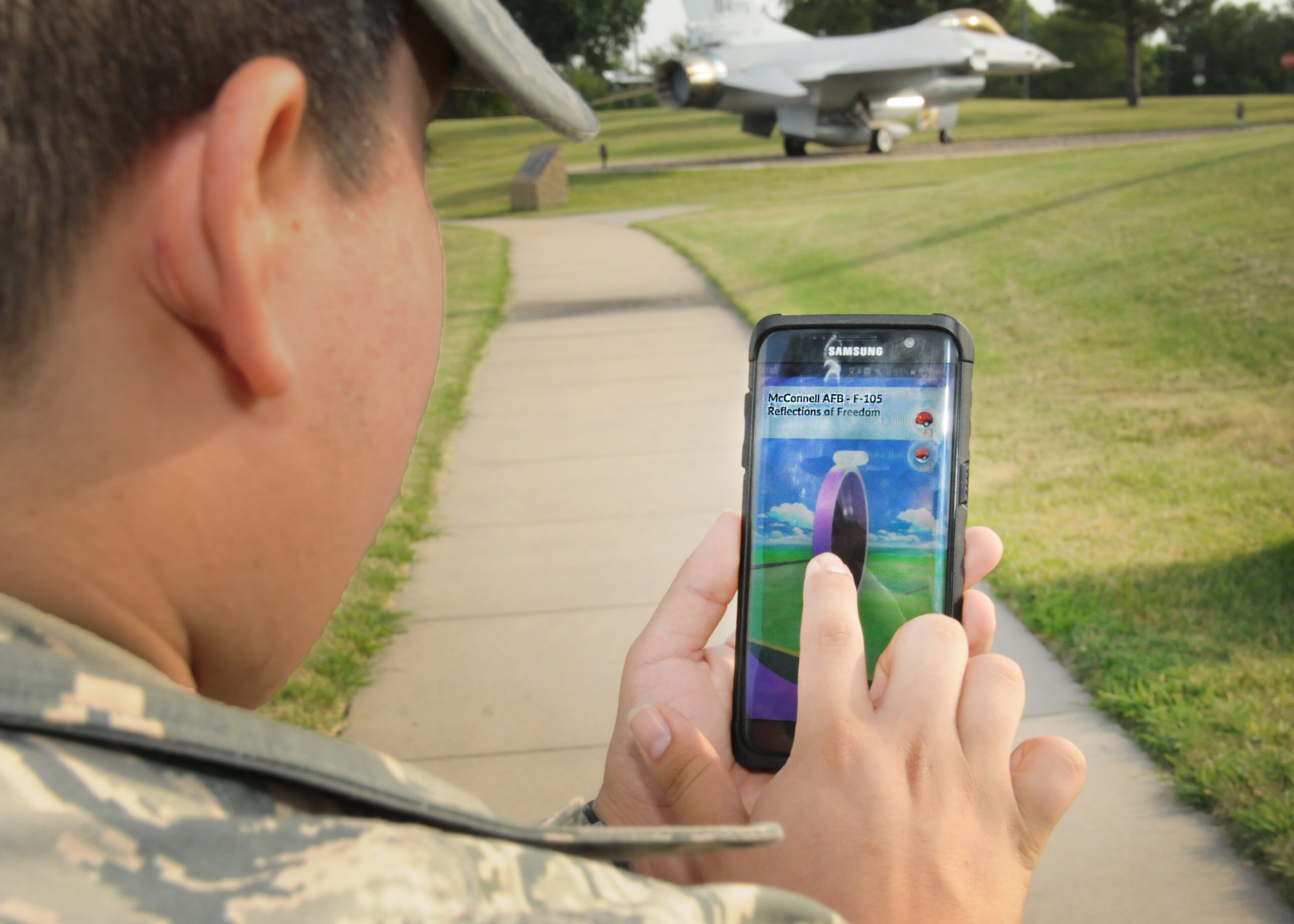 Airman 1st Class Orlando Saenz, services specialist, 184th Force Support Squadron, finds a Pokéstop in the airpark at McConnell Air Force Base July 27. The purpose of Pokémon Go is to get gamers off the couch and out in the community through an interactive game.