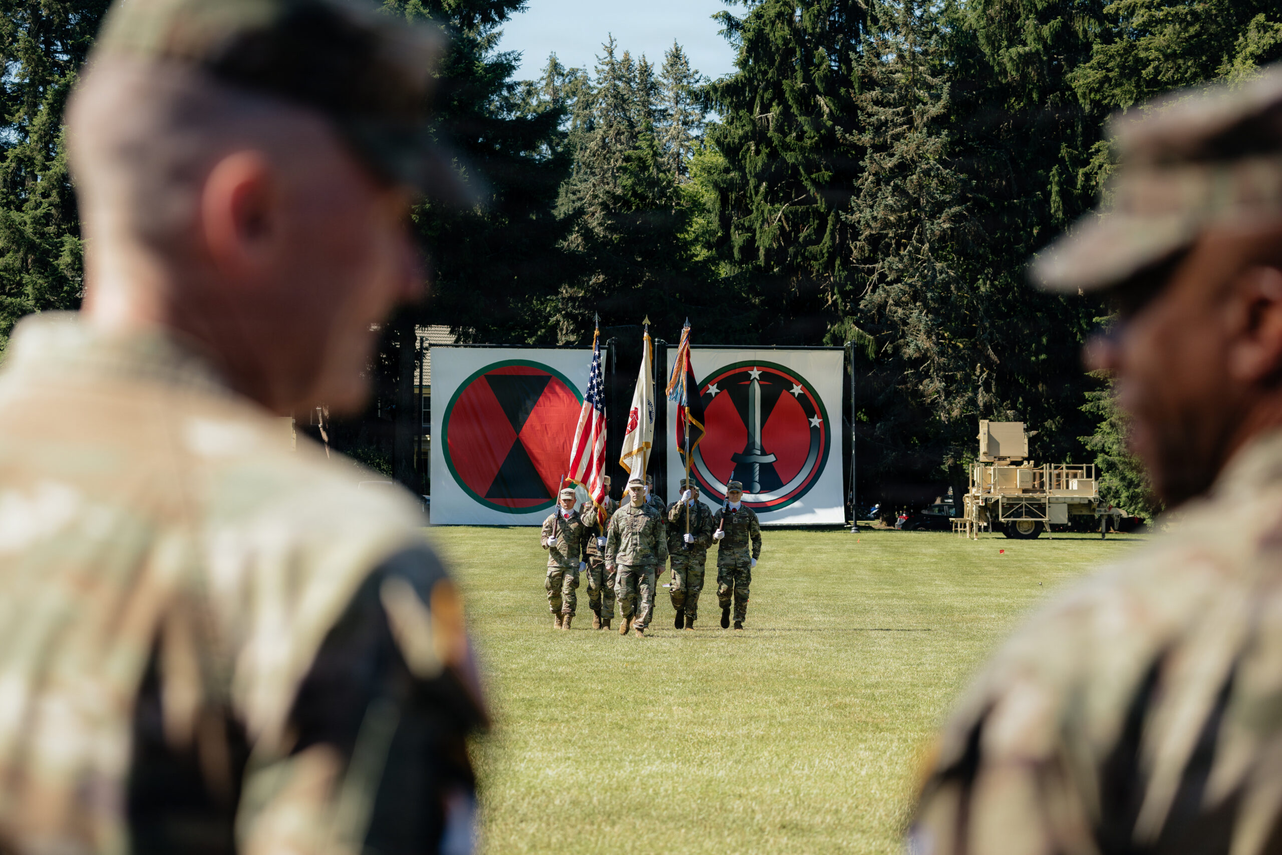 Maj. Gen. Bernard Harrington, 7th Infantry Division (Multi-Domain Command - Pacific) Commanding General (left), and Gen. Ronald Clark, U.S. Army Pacific Commanding General (right), look on as Col. Andrew Gallo, 7th Infantry Division (Multi-Domain Command - Pacific) Chief of Staff (center), marches the color guard during the 7th ID (MDC-PAC) redesignation ceremony at Joint Base Lewis-McChord, Wash., June 18, 2026. The redesignation honors the Bayonet Division’s legacy while establishing 7th ID (MDC-PAC) as the Army’s newest theater-enabling command, built to integrate maneuver, fires, air defense, cyber, space, electronic warfare, intelligence, unmanned systems, sustainment, and command and control in support of the Joint Force across the Pacific. (U.S. Army photo by Staff Sgt. Cayce Watson)