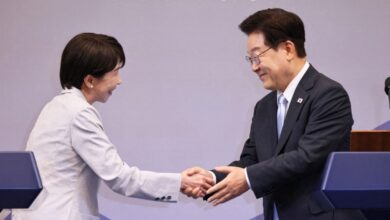 Japanese Prime Minister Sanae Takaichi (left) shakes hands with South Korean President Lee Jae-myung