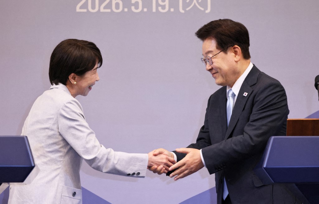 Japanese Prime Minister Sanae Takaichi (left) shakes hands with South Korean President Lee Jae-myung