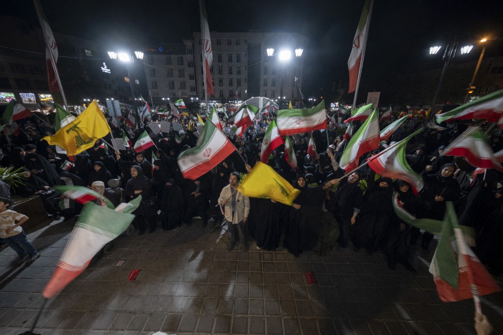 Pro-government supporters wave Iranian national flags and Lebanon's Hezbollah flags while participating in a nightly rally in a business district in downtown Tehran, Iran, on May 22, 2026.