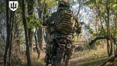 Ukraine soldiers ride a motorcycle.