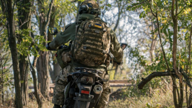 Ukraine soldiers ride a motorcycle.