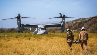The V-22 Osprey in the background as medics use it for rescue or evacuation