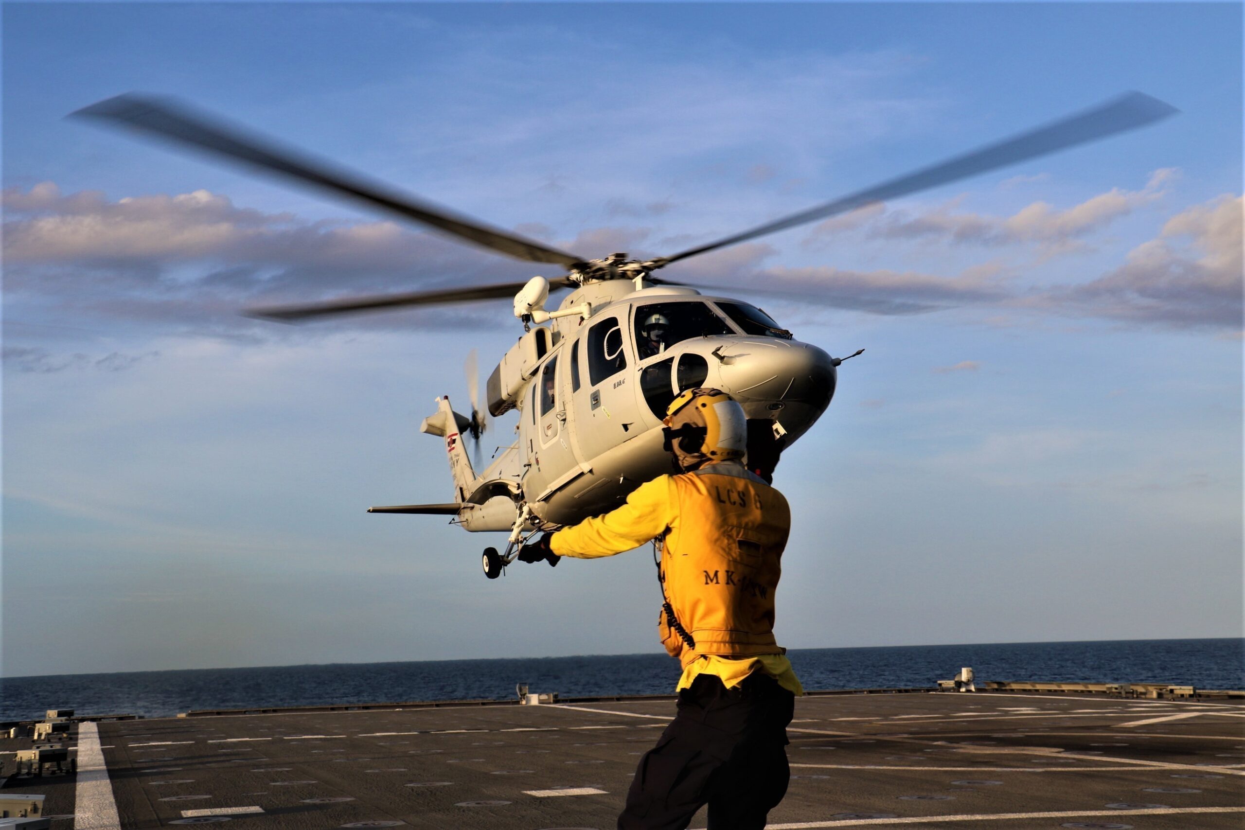 220525-N-EU544-8243 GULF OF THAILAND (May 25, 2022) Boatswain’s Mate 2nd Class David Miller, from Chicago, directs a Royal Thai Navy Sikorsky S-76B helicopter during cross-deck landing qualifications on the flight deck aboard the Independence-variant littoral combat ship USS Jackson (LCS 6) during Cooperation Afloat Readiness and Training (CARAT) Thailand 2022. CARAT Thailand is an annual bilateral naval exercise between the U.S. Navy and Royal Thai Navy. Thailand has been part of the CARAT exercise series since 1995. Now in its 28th year, the CARAT series comprises multiple multinational exercises, designed to enhance U.S. and allied and partner navies’ abilities to operate together in response to traditional and non-traditional maritime security challenges in the Indo-Pacific. (U.S. Navy photo by Gunner’s Mate 2nd Class Joel Maldonado)