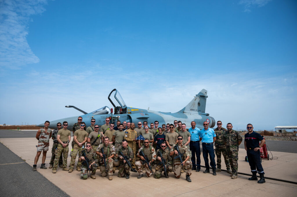 U.S. Air Force Airmen from the 776th Expeditionary Air Base Squadron and French air force personnel pose for a group photo in front of a French air force Dassault Mirage 2000