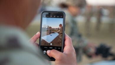 U.S. Army Sgt. 1st Class Victor Cordero, a platoon sergeant assigned to 1st Battalion, 36th Infantry Regiment, 1st Brigade Combat Team, uses his smartphone to take a photo of his wife, Staff Sgt. Jessica Cordero, as she disassembles an M4 Carbine Rifle during the weapons lane portion of the Expert Infantryman Badge/Expert Soldier Badge (EIB/ESB) competition March 31 at Fort Bliss, Texas. Staff Sgt. Cordero, a financial management technician assigned to 4th Financial Management Support Unit, Special Troops Battalion, 1st Armored Division Support Brigade, competed in the ESB competition earning the coveted ESB setting her apart from her peers as a symbol of excellence. The "Ready First" 1st Brigade Combat Team, 1st Armored Division hosted the EIB/ESB competition which included a series of rigorous and demanding events such as the Expert Physical Fitness Assessment, day and night land navigation, individual weapons qualification, medical lanes, patrol lanes, and a 12-mile road march. (U.S. Army Photo by Sgt. Wheeler Brunschmid).