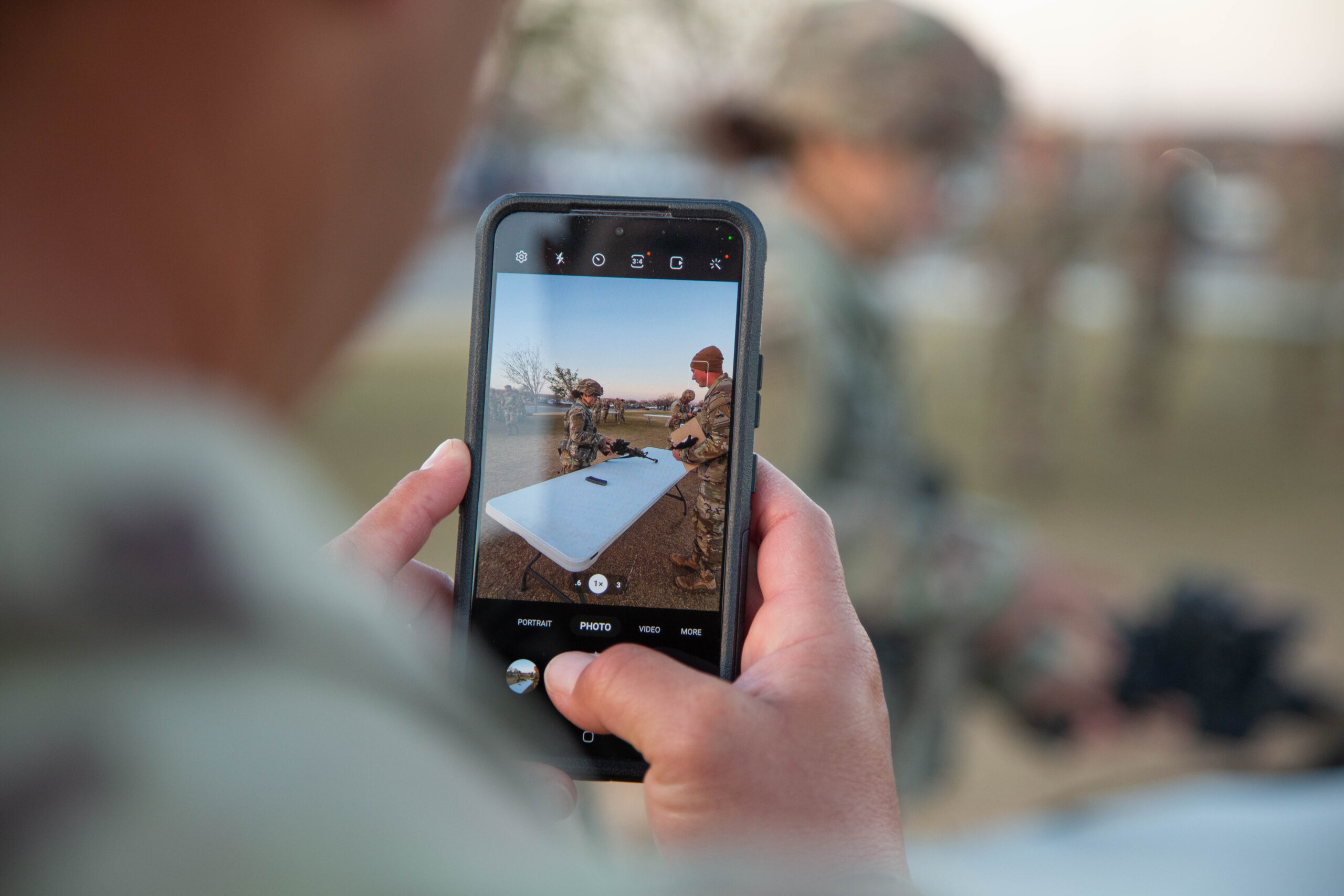 U.S. Army Sgt. 1st Class Victor Cordero, a platoon sergeant assigned to 1st Battalion, 36th Infantry Regiment, 1st Brigade Combat Team, uses his smartphone to take a photo of his wife, Staff Sgt. Jessica Cordero, as she disassembles an M4 Carbine Rifle during the weapons lane portion of the Expert Infantryman Badge/Expert Soldier Badge (EIB/ESB) competition March 31 at Fort Bliss, Texas. Staff Sgt. Cordero, a financial management technician assigned to 4th Financial Management Support Unit, Special Troops Battalion, 1st Armored Division Support Brigade, competed in the ESB competition earning the coveted ESB setting her apart from her peers as a symbol of excellence. The "Ready First" 1st Brigade Combat Team, 1st Armored Division hosted the EIB/ESB competition which included a series of rigorous and demanding events such as the Expert Physical Fitness Assessment, day and night land navigation, individual weapons qualification, medical lanes, patrol lanes, and a 12-mile road march. (U.S. Army Photo by Sgt. Wheeler Brunschmid).