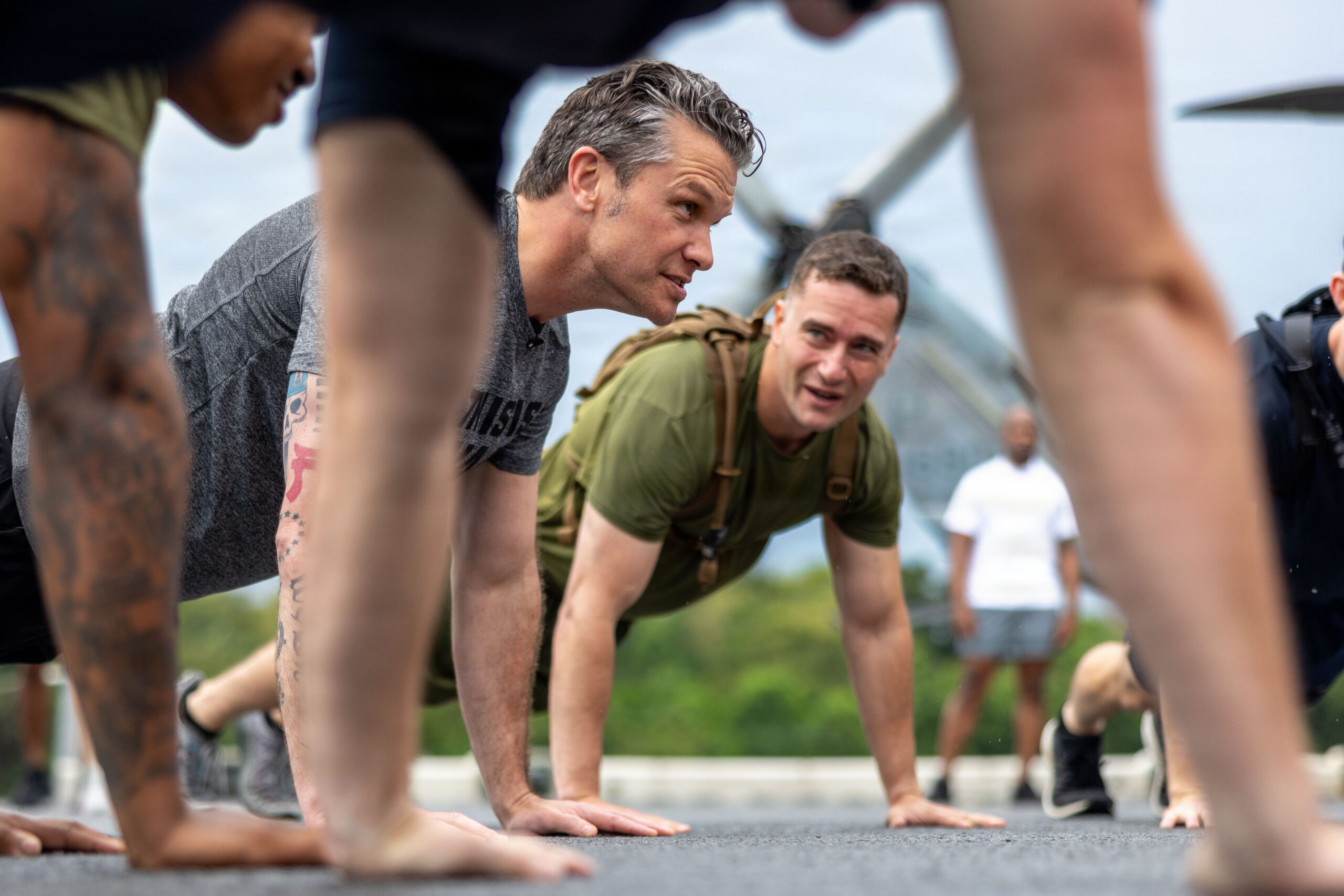 Secretary of War Pete Hegseth does push-ups with U.S. Marines from the 11th Marine Expeditionary Unit and Sailors assigned to Wasp-class amphibious assault ship USS Boxer (LHD 4) during a physical training event in Singapore, May 29, 2026. The 11th MEU, embarked aboard the Boxer Amphibious Ready Group, is a persistent, combat credible force contributing to deterrence and crisis response in the U.S. 7th Fleet area of operations. U.S. 7th Fleet, the U.S. Navy's largest forward-deployed numbered fleet, routinely interacts and operates with allies and partners to preserve a free and open Indo-Pacific. (U.S. Marine Corps photo by Sgt. Trent A. Henry)