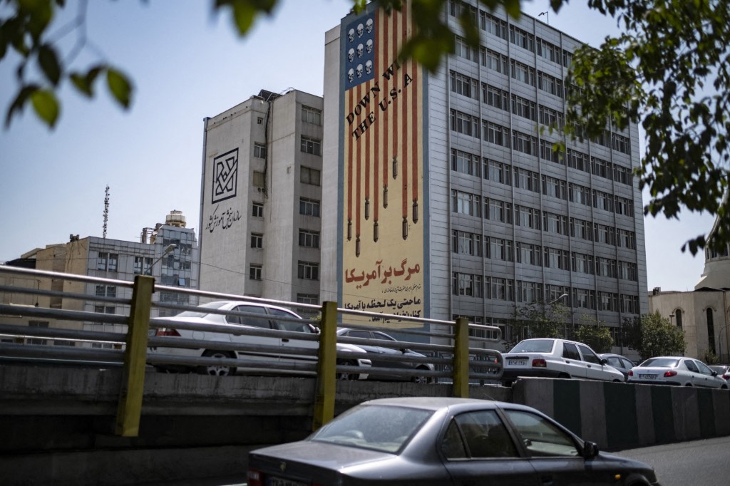 Vehicles move along an avenue beneath an anti-US mural in Tehran, Iran, on July 16, 2026.
