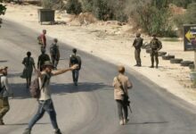 Israeli settlers march through the West Bank town of Sarra as Israeli forces provide security during a march commemorating two Israelis killed a week earlier, July 31, 2026. Clashes erupted along the route, leaving one Palestinian wounded. (AFP)