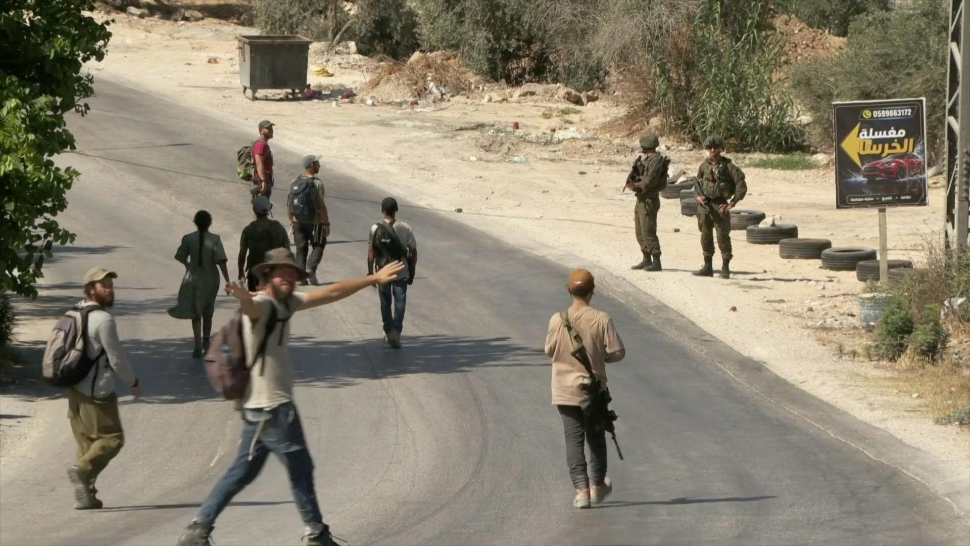 Israeli settlers march through the West Bank town of Sarra as Israeli forces provide security during a march commemorating two Israelis killed a week earlier, July 31, 2026. Clashes erupted along the route, leaving one Palestinian wounded. (AFP)