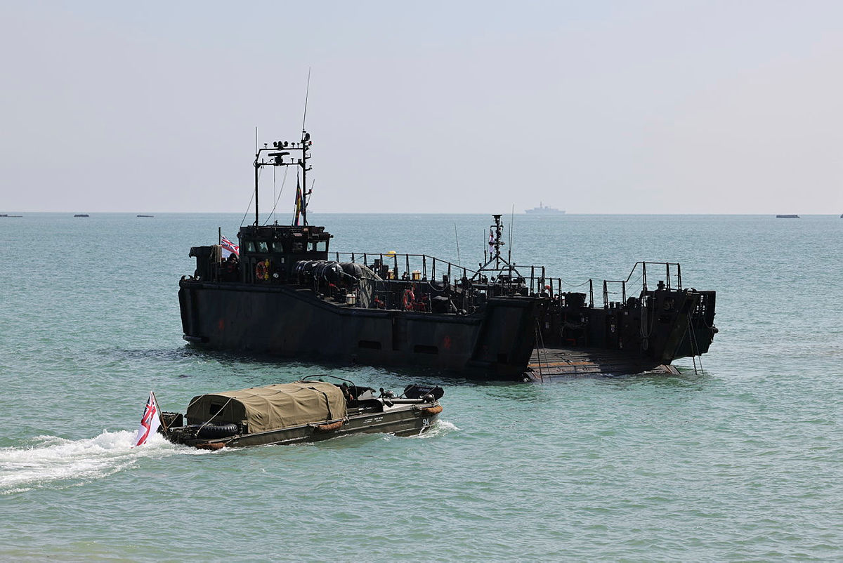 A Royal Navy LCU Mk10 landing craft and a vintage WWII DUKW amphibious vehicle flying the White Ensign flag during the D-Day 80th anniversary commemoration.