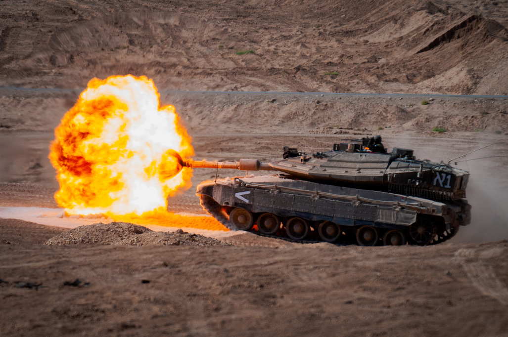 An Israeli Defense Forces Merkava Mark 4 tank fire its 120mm canon