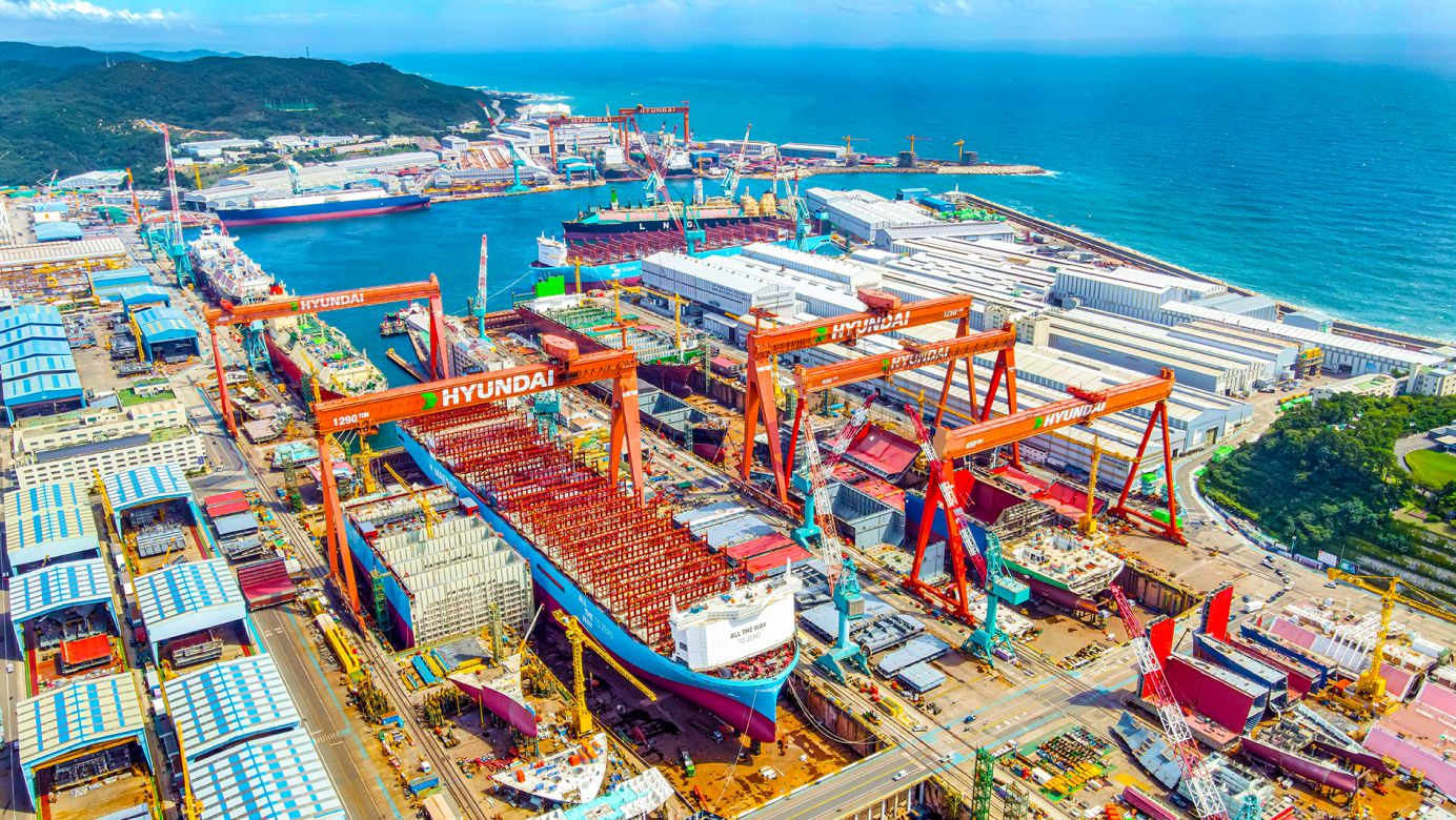 Aerial view of HD Hyundai Heavy Industries' Ulsan shipyard with ships under construction and multiple dry docks in South Korea.